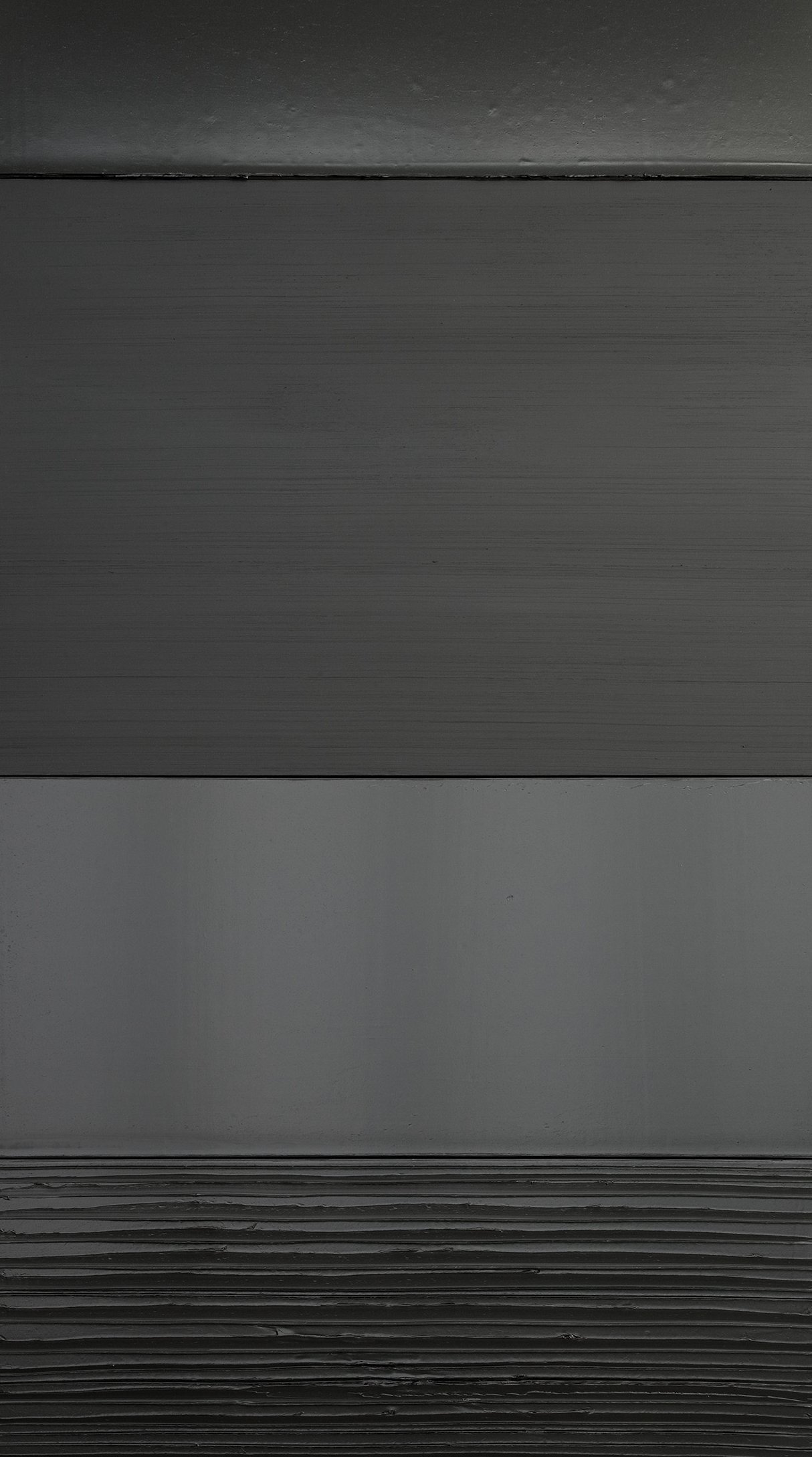 L'image présente un champ de nuances de gris, avec plusieurs bandes horizontales. Les textures varient légèrement, allant de surfaces lisses à des zones plus texturées ou rayées. L'éclairage contribue à créer un effet de profondeur, mettant en valeur les différences de ton et de finition entre les différentes sections. L'ensemble donne une impression moderne et minimaliste.