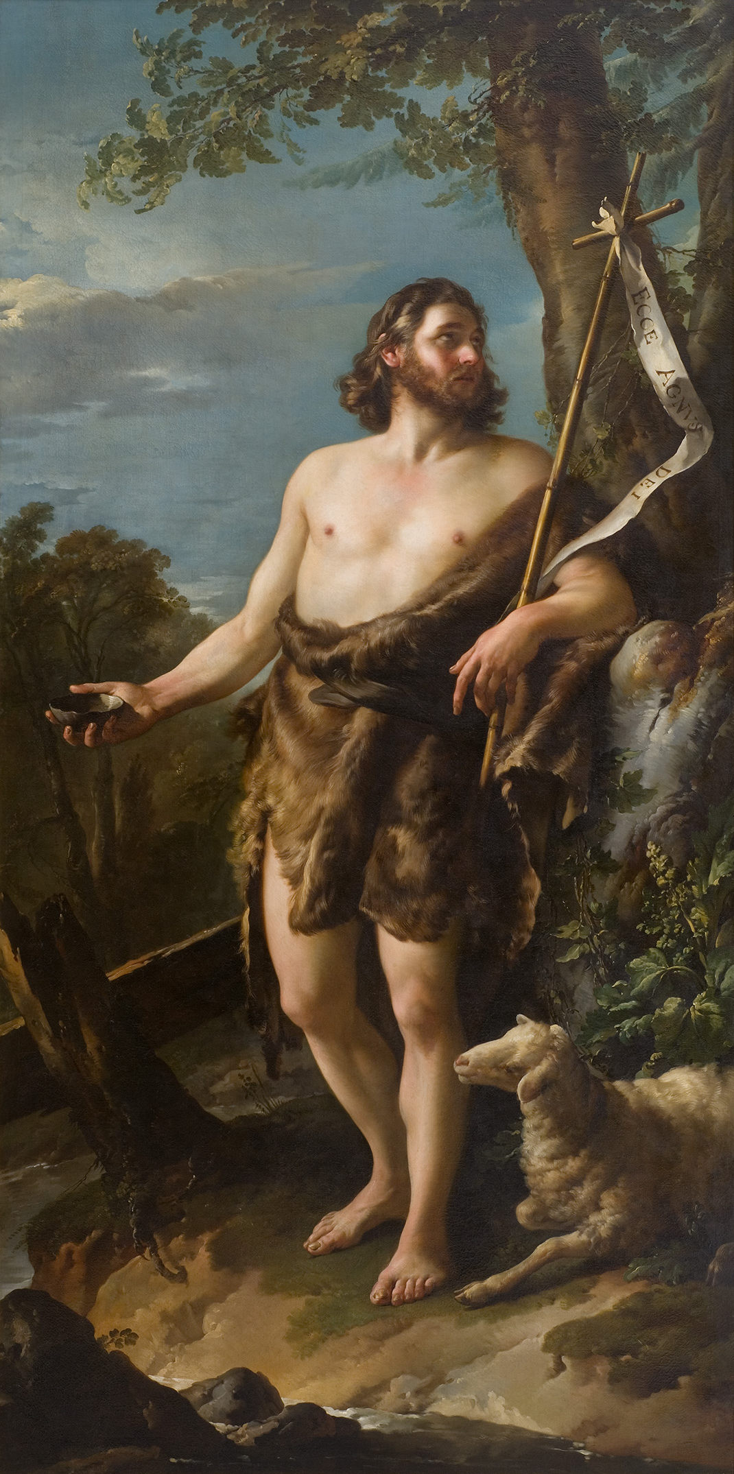 L'image représente une figure mythologique ou religieuse, probablement Saint Jean-Baptiste. Il se tient debout, vêtu d'une peau de bête, avec un bâton à la main surmonté d'une croix. Il porte également un regard pensif et contemplatif, se tenant dans un paysage naturel. À ses pieds, un agneau est représenté, symbolisant souvent l'innocence. La lumière et les ombres accentuent les détails de son visage et de son corps, soulignant l'intensité de l'expression et la texture de son vêtement. Le fond est constitué d'arbres et d'un ciel nuageux, créant une atmosphère sereine.