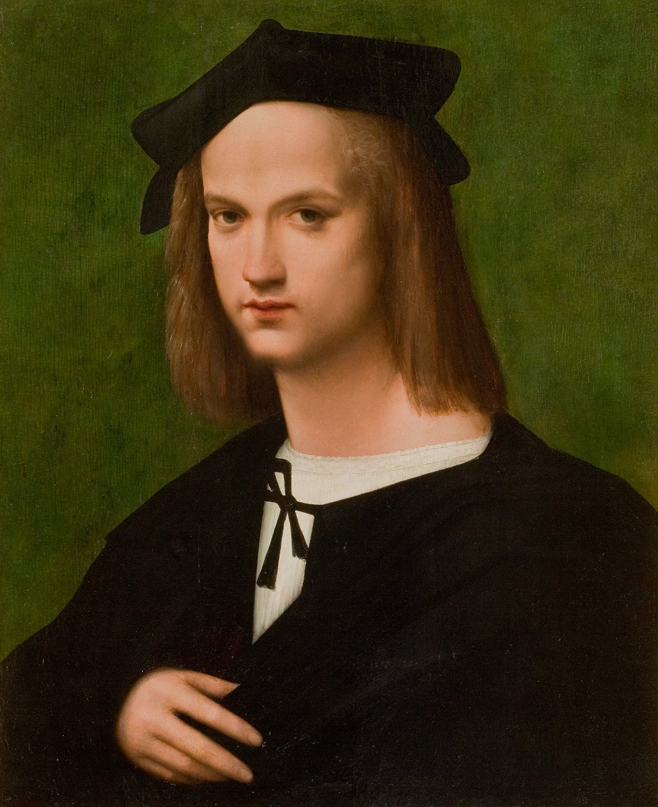 L'image représente un portrait d'un jeune homme, probablement de la Renaissance. Il a les cheveux longs et exige une coiffe noire, typique de l'époque. Son expression est calme et réfléchie, et il porte une tunique foncée avec un col blanc. L'arrière-plan est d'un vert uni, ce qui met en valeur son visage et sa tenue. Les détails du tableau témoignent d'une maîtrise technique et d'un style typique des portraits de cette période.
