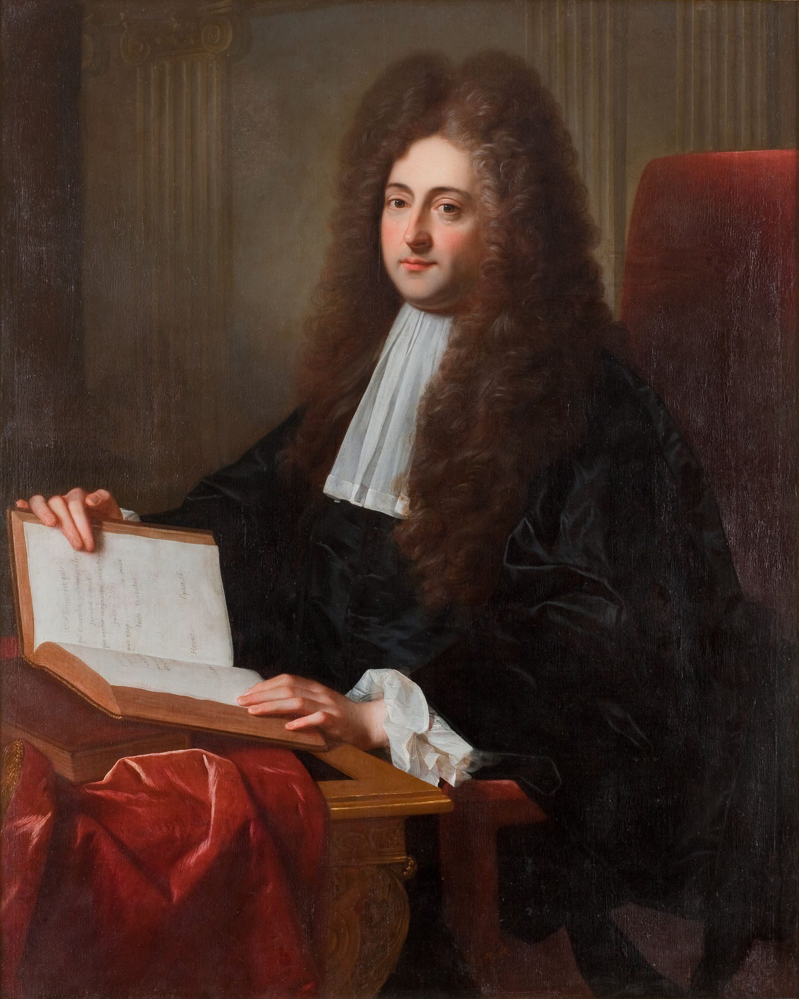 L'image représente un homme assis, vêtu d'une robe noire. Il a de longs cheveux bouclés et porte un col blanc. Dans ses mains, il tient un livre ouvert sur ses genoux. Le décor en arrière-plan suggère un cadre formel, avec des colonnes. L'éclairage met en avant son visage et son expression, donnant une impression de dignité et de sérieux.