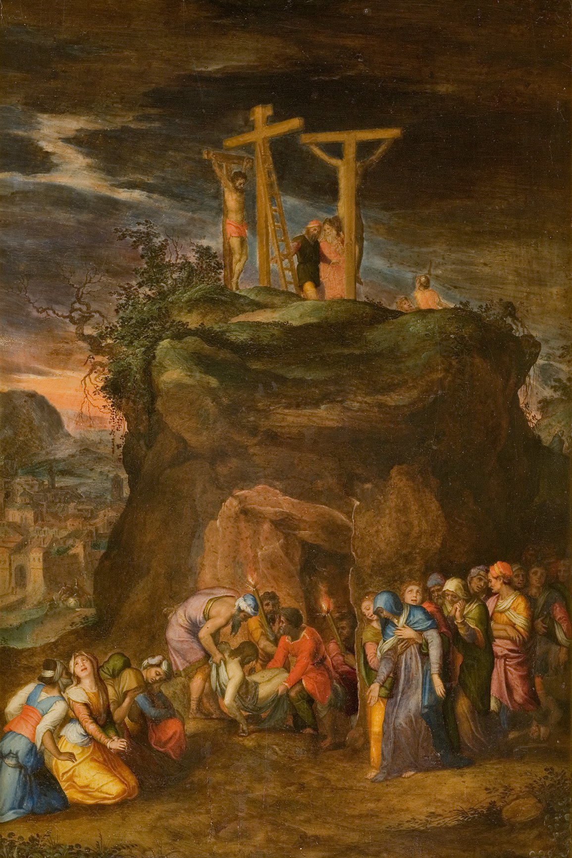 L'image représente une scène religieuse intense et émotive. Au premier plan, un groupe de personnes se rassemble autour d'une grotte, observant une crucifixion qui se déroule sur une colline au-dessus. Deux croix sont érigées, symbolisant la crucifixion, avec des figures humaines visibles sur celles-ci. À l'arrière-plan, on aperçoit un paysage avec des maisons et une lumière crépusculaire, créant une atmosphère dramatique. Les expressions des personnages montrent une grande tristesse et un sentiment de désespoir, accentuant la gravité de la scène.