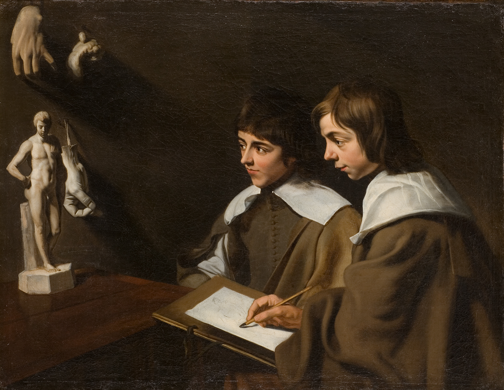 L'image représente deux jeunes garçons, chacun vêtu d'un manteau sombre avec des cols blancs, concentrés sur un processus de dessin. L'un d'eux tient un carnet de croquis sur lequel il dessine, tandis que l'autre semble observer attentivement. À côté d'eux, il y a des sculptures sur la surface d'une table sombre, dont une statue d'un homme nu et quelques éléments sculptés accrochés au mur. L'éclairage est subtil et met en valeur les visages des garçons ainsi que les détails des sculptures, créant une atmosphère d'intimité et de concentration sur l'apprentissage artistique.