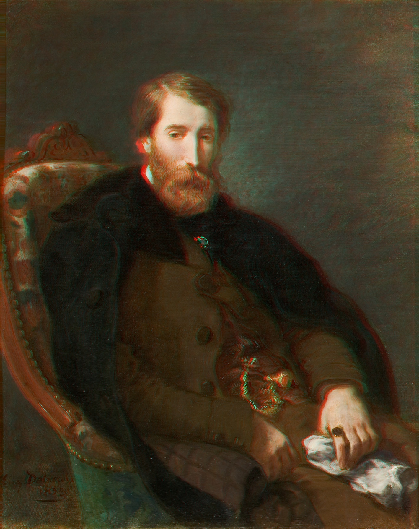 L'image présente un portrait d'un homme assis sur une chaise. Il a une barbe et des cheveux longs, et il porte des vêtements sombres, dont un manteau. L'expression de son visage est sérieuse, et il tient un morceau de tissu dans une main. Le fond de l'image est dans des teintes plus neutres, mettant en valeur le sujet. 