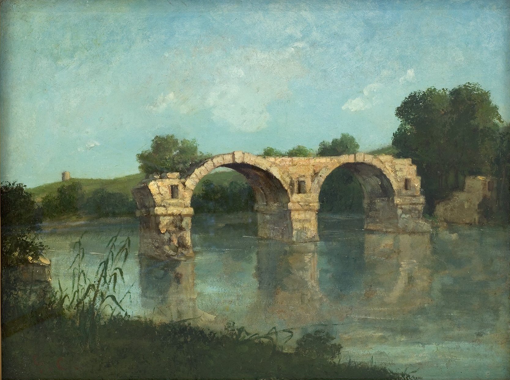 L'image représente un paysage paisible mettant en avant un vieux pont en pierre qui enjambe une rivière calme. Les arches du pont, légèrement érodées par le temps, se reflètent dans l'eau tranquille. En arrière-plan, on peut apercevoir des collines verdoyantes et quelques arbres. Le ciel est d'un bleu clair avec quelques nuages, ce qui apporte une atmosphère sereine à la scène. L'ensemble de la composition évoque la beauté naturelle et la tranquillité d'un cadre rural.