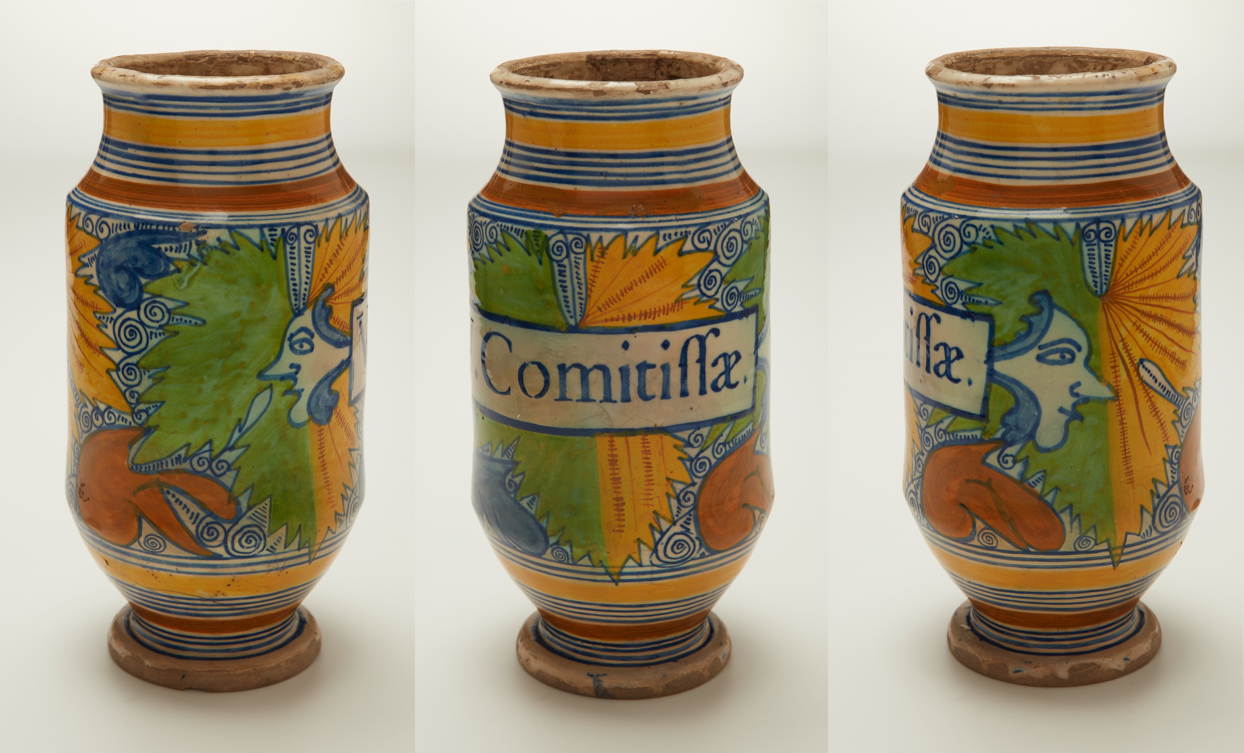 L'image présente un vase décoratif aux couleurs vives. Le vase a une forme bulbeuse avec un col évasé. Il est orné de motifs géométriques et floraux, notamment des couleurs jaune, bleu et orange. Sur l'un des côtés, on peut lire le mot "Comitifa", inscrit dans un rectangle central. Les figures humaines stylisées complètent la décoration, ajoutant une touche artistique à l'ensemble. Ce vase montre une belle harmonie entre les couleurs et les motifs, témoignant d'un savoir-faire artisanal.