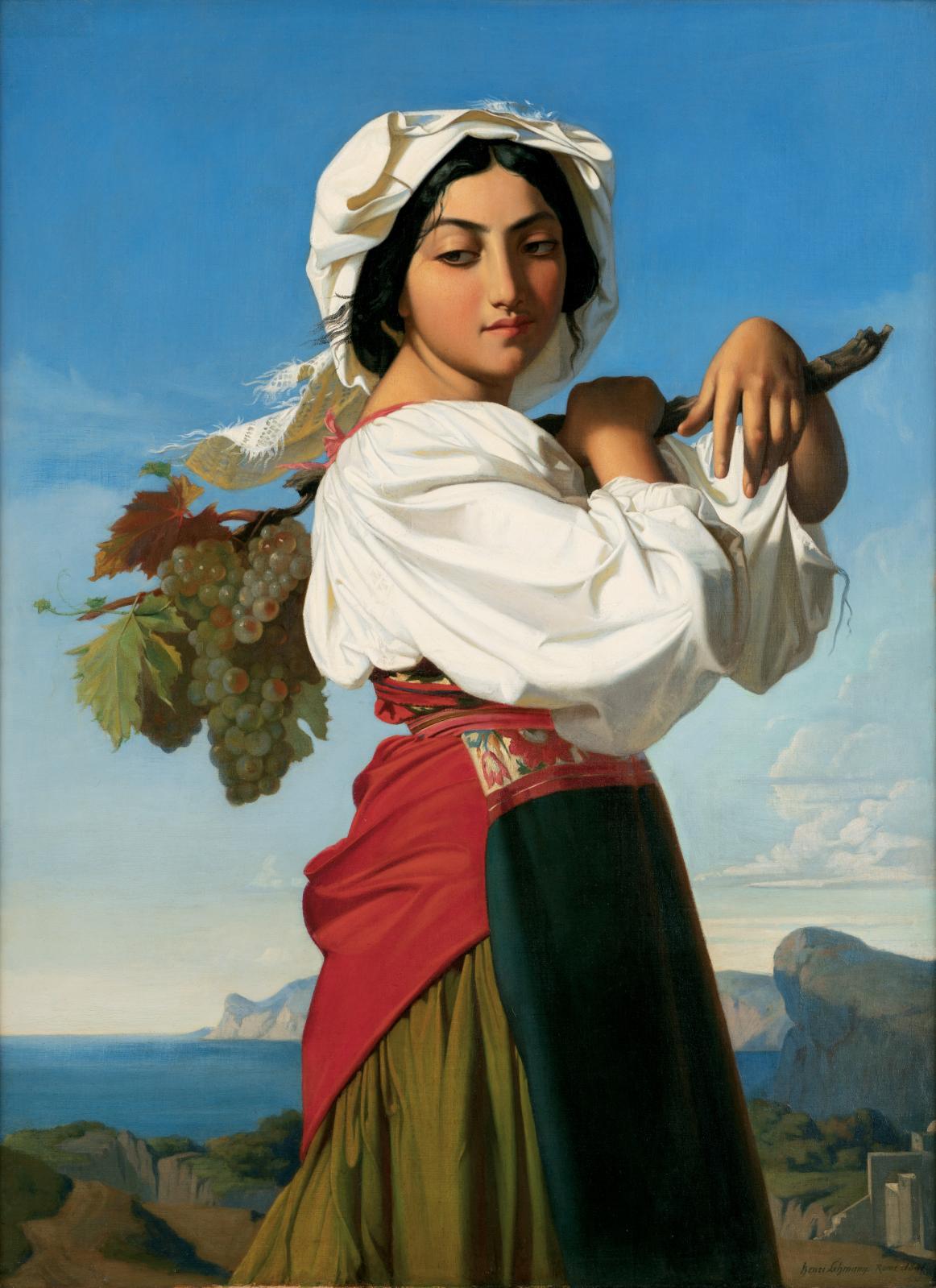 Cette image représente une jeune femme au port élégant, vêtue d'une tenue traditionnelle. Elle porte un foulard sur la tête et une chemise blanche, ainsi qu'une jupe colorée. Elle se tient de profil, avec un sourire subtil, tout en portant sur son épaule une branche chargée de raisins et de feuilles. En arrière-plan, un paysage naturel fait de collines et d'une mer bleue s'étend sous un ciel lumineux et dégagé. L'ensemble dégage une impression de fraîcheur et de vitalité, accentuant la beauté du monde rural.