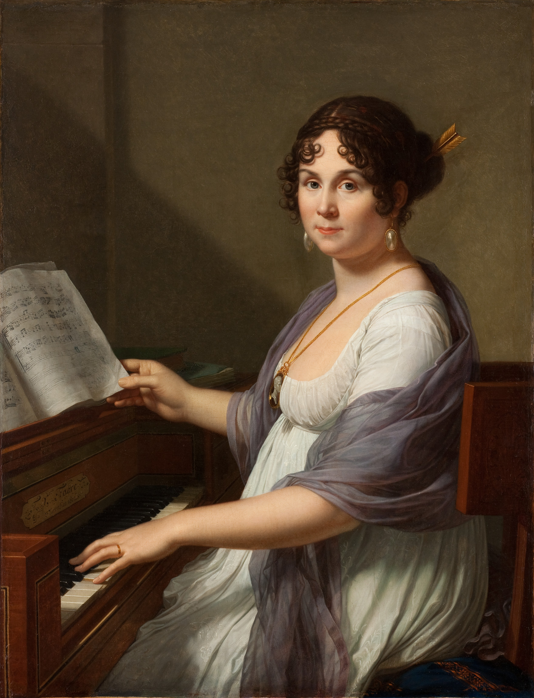 L'image représente une femme assise devant un piano. Elle porte une robe blanche élégante, avec une étole légère drapée sur ses épaules. Ses cheveux sont coiffés en boucles, avec un accessoire dans les cheveux. Elle regarde le spectateur avec un léger sourire, tandis qu'elle joue une note sur le piano tout en tenant une partition de musique. L'arrière-plan est sobre, mettant en valeur la femme et son instrument. L'ensemble dégage une atmosphère de tranquillité et de sophistication.