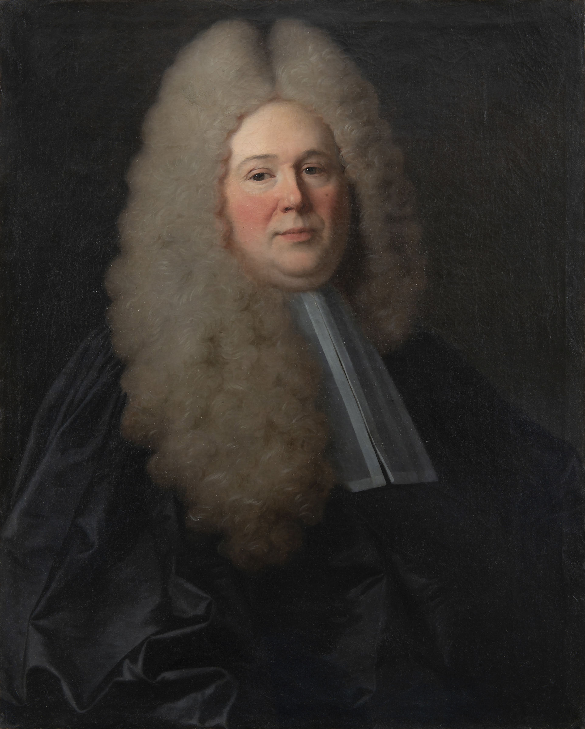 L'image représente un portrait d'un homme au visage plutôt jovial, avec de longs cheveux bouclés et volumineux qui encadrent son visage. Il porte une robe sombre typique des juges ou des avocats de l'époque, ainsi qu'une collerette blanche. Son expression est confiante et il semble se tenir fier, ce qui donne une impression de dignité. Le fond de l'image est sombre, ce qui met en valeur les détails du visage et de la coiffure.