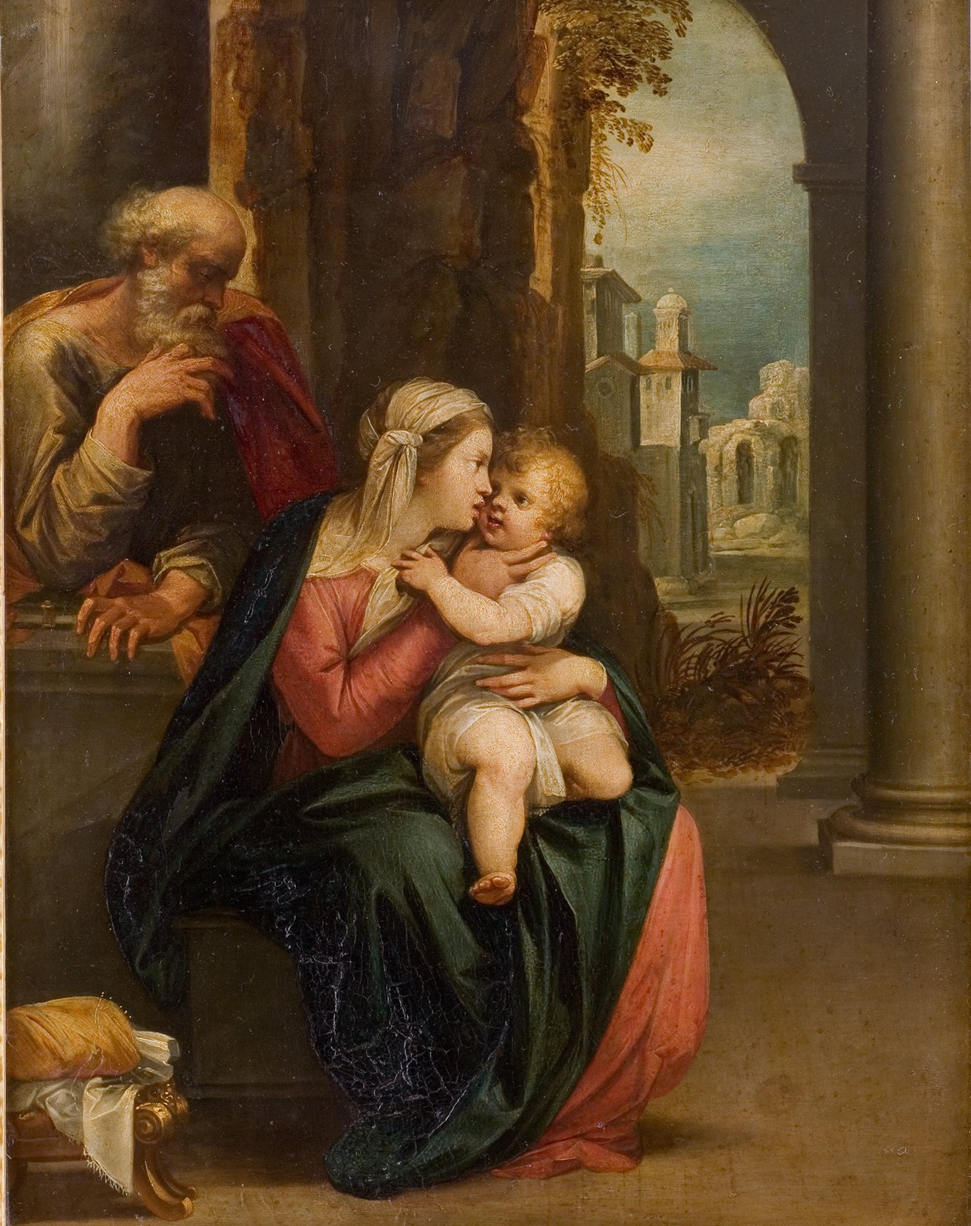 L'image représente une scène biblique avec la Vierge Marie tenant l'enfant Jésus dans ses bras. Marie, vêtue d'une robe colorée, incline la tête vers son bébé avec affection. À l'arrière-plan, on aperçoit Saint Joseph, qui semble pensif. Le décor est riche, avec des colonnes et un paysageArchitectural ruinée en arrière-plan, ajoutant une atmosphère de sérénité et de contemplation à la scène. Les couleurs chaudes et les détails des vêtements mettent en valeur la tendresse et la relation entre les personnages.