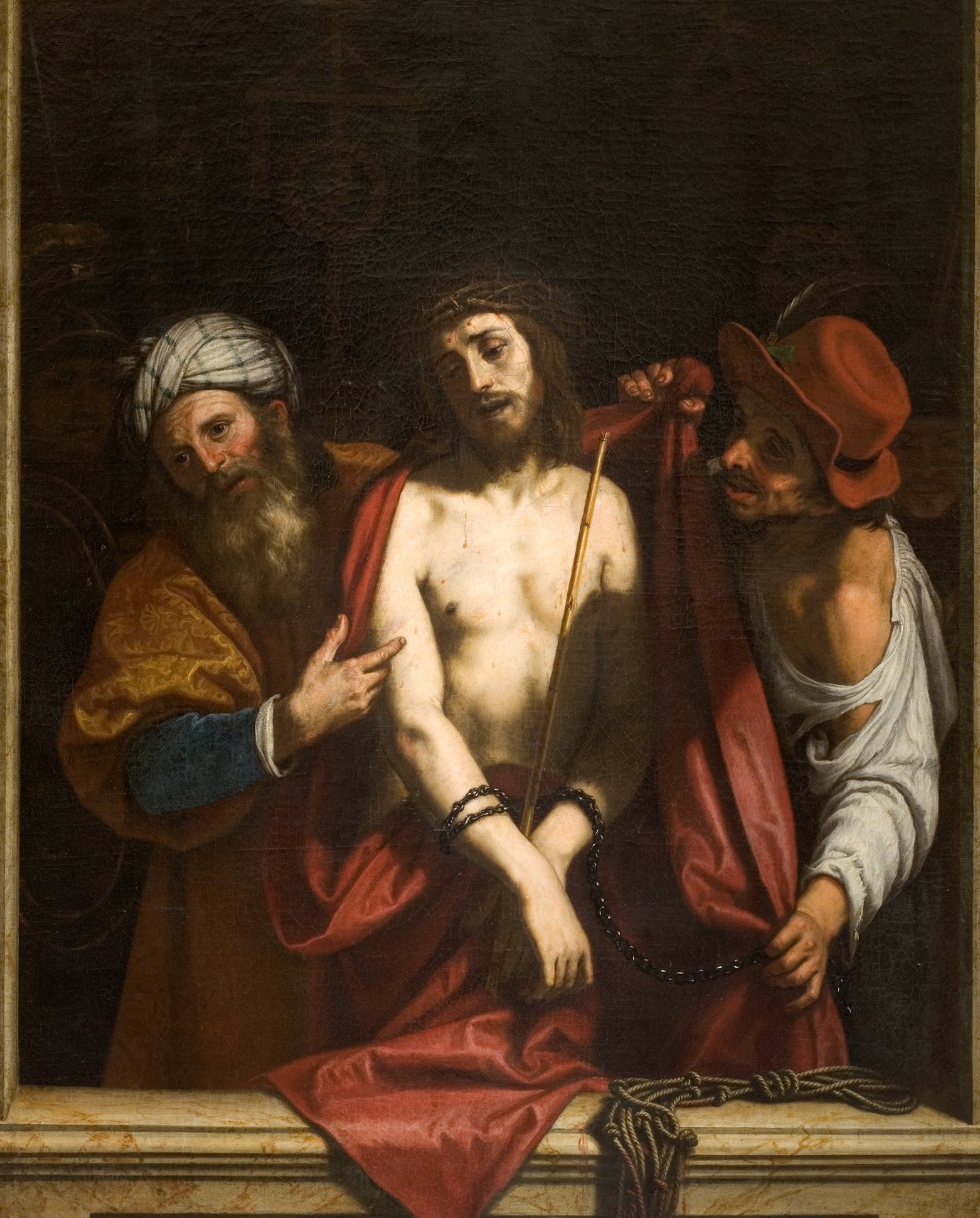 Cette image représente une scène biblique avec Jésus-Christ au centre, montrant des expressions de douleur et de souffrance. Il est entouré de deux personnages : l'un, à gauche, porte un turban et semble discuter ou interroger, tandis que l'autre, à droite, est vêtu d'un chapeau rouge. Le tableau évoque des thèmes de jugement et de compassion, avec un fond sombre qui accentue les figures principales. Les détails des vêtements et des expressions des personnages ajoutent une dimension dramatique à la scène.