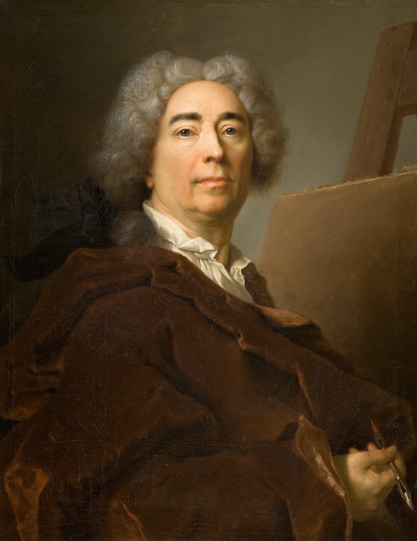 Cette image représente un portrait d'un homme avec des cheveux gris bouclés et un regard sérieux. Il est vêtu d'une robe brune et tient un pinceau, suggérant qu'il est un artiste ou un peintre. En arrière-plan, on peut voir un chevalet, ce qui renforce l'idée qu'il est engagé dans le processus de création artistique. L'éclairage est doux, mettant en valeur son visage et les textures de ses vêtements.