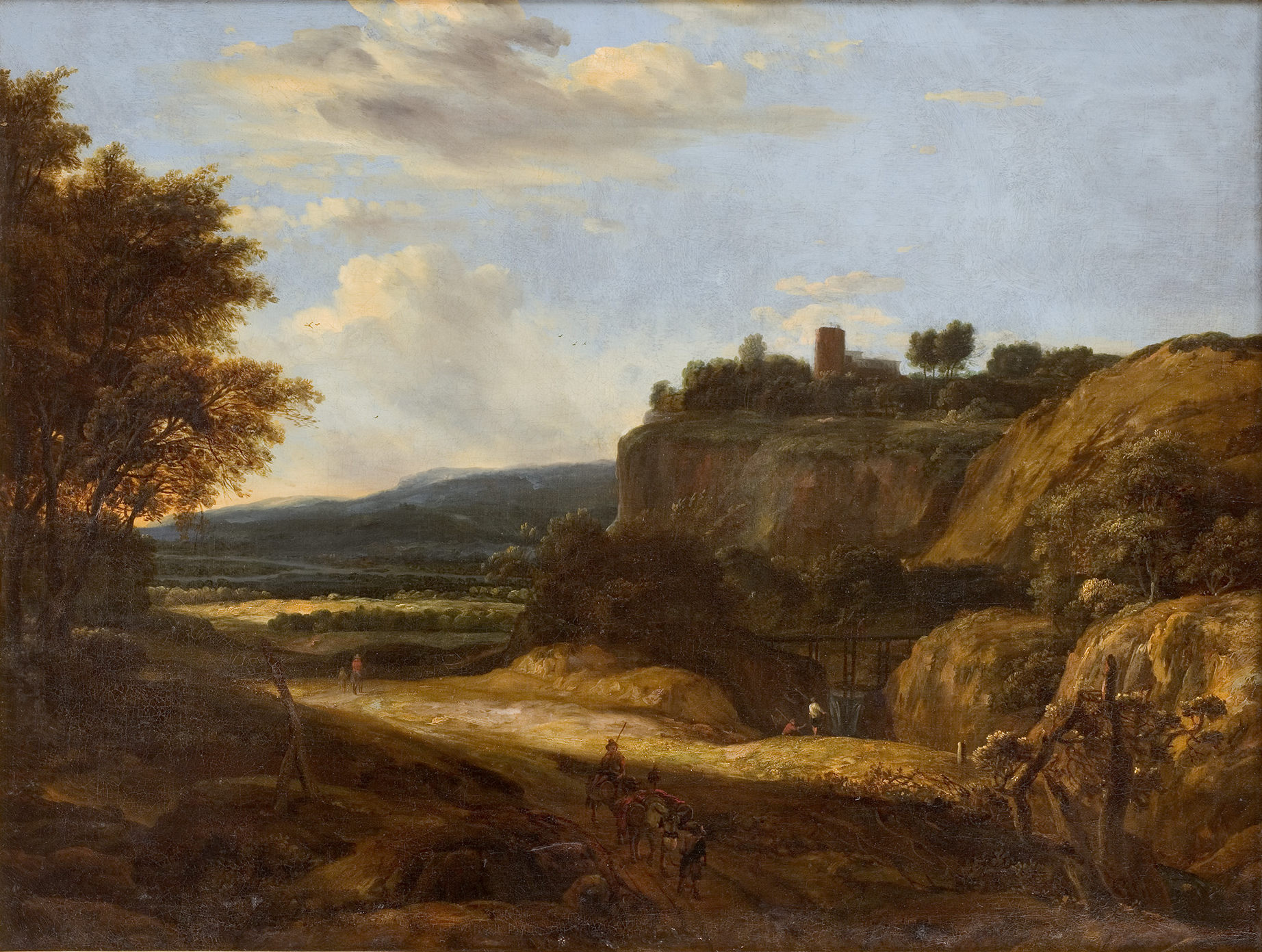 L'image représente un paysage rural paisible. On y voit une vue d'une colline surmontée d'une petite tour ou d'un bâtiment, entourée d'arbres. Au premier plan, un chemin sinueux traverse la scène, et quelques figures humaines y sont visibles, probablement des paysans ou des voyageurs. À l'arrière-plan, des montagnes sont visibles sous un ciel partiellement nuageux, créant une atmosphère sereine et naturelle. La lumière douce du soleil ajoute une touche chaleureuse à l'ensemble du tableau.