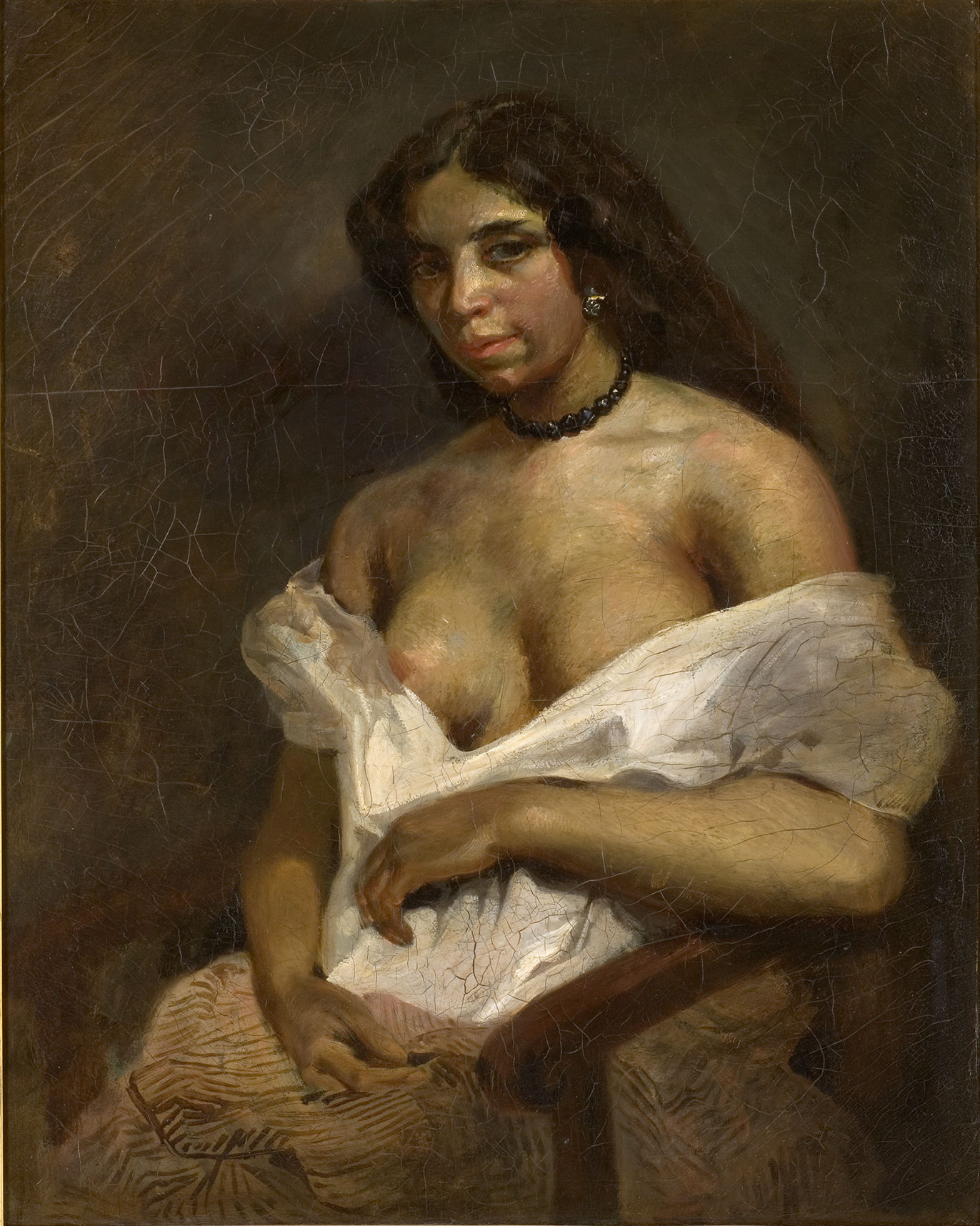 L'image représente un portrait d'une femme assise. Elle a les cheveux longs et foncés, et son expression est à la fois intense et mystérieuse. Elle porte une chemise blanche, légèrement déshabillée, qui laisse entrevoir ses épaules. La lumière met en valeur son visage et sa posture, tandis que le fond est sombre, ce qui accentue son apparence. L'œuvre dégage une atmosphère de sensualité et de profondeur.