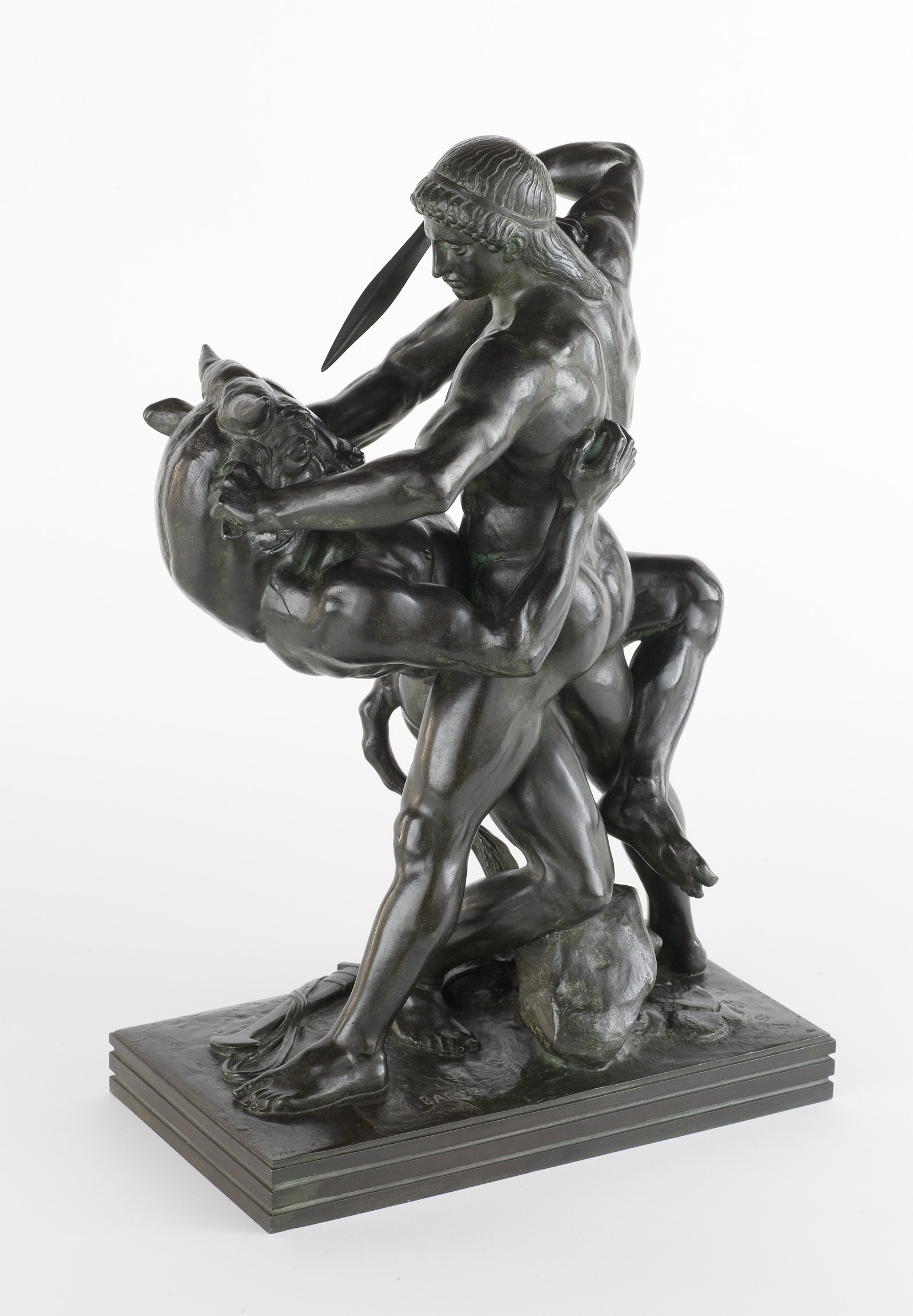 L'image présente une sculpture représentant une scène de lutte entre deux figures humaines. L'une des figures semble dominer l'autre, avec une posture musclée et dynamique. L'artiste a utilisé des formes stylisées pour rendre le mouvement et l'intensité de la confrontation. Les détails, tels que les muscles saillants et les expressions intenses, évoquent une scène dramatique et héroïque. La sculpture repose sur une base solide, ajoutant à son impression de puissance et de force.