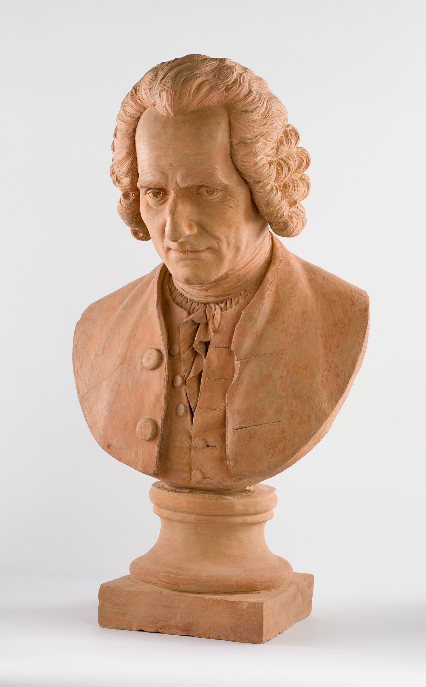 L'image montre un buste en terre cuite d'un homme portant des vêtements du XVIIIe siècle. Il a des cheveux bouclés et un visage sérieux, avec des détails soigneusement sculptés qui reflètent une expression contemplative. Le buste est monté sur un socle circulaire, et l'ensemble évoque un style artistique classique, typique des sculptures de cette époque.