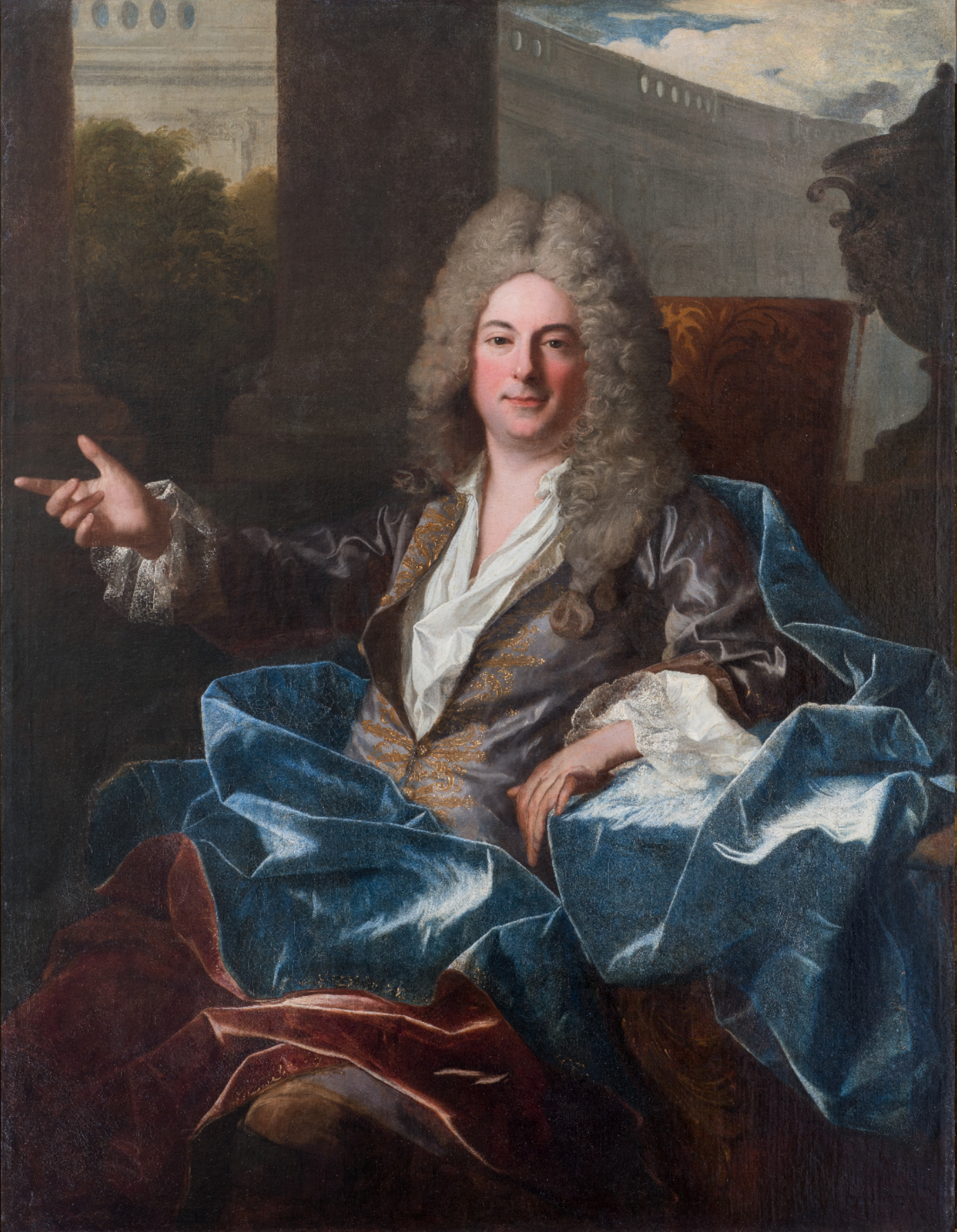 L'image représente un portrait d'un homme élégant, assis dans un fauteuil. Il porte une veste ornée et un large manteau bleu, avec des cheveux longs et bouclés. Son expression est détendue et il semble pointer du doigt avec un geste assuré. En arrière-plan, on aperçoit des colonnes et un paysage, suggérant un environnement architectural. La lumière douce met en valeur les détails de ses vêtements et la texture de ses cheveux.