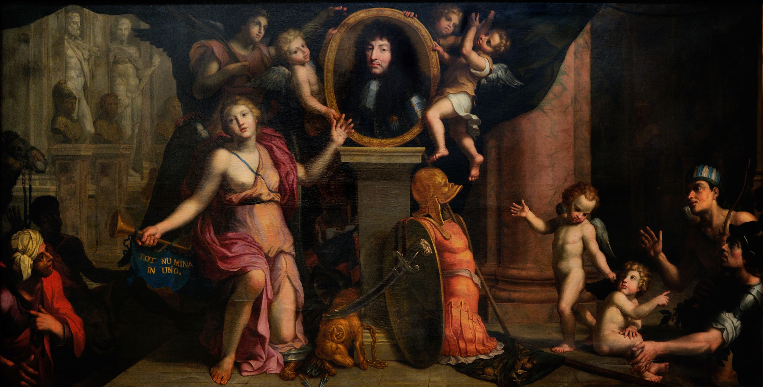L'image représente une scène allégorique chargée de symbolisme. Au centre, une femme, souvent considérée comme une allégorie de la France ou de la gloire, se tient devant un portrait de roi, probablement Louis XIV. Elle est entourée d'anges et de putti, qui semblent l'encadrer. À ses pieds se trouvent des éléments militaires, tels qu'une armure et une épée, symbolisant la force et la protection. D'autres figures, y compris des enfants, ajoutent une dimension dynamique à la composition, tandis qu'un lion au premier plan évoque la puissance. L'ensemble dégage une atmosphère solennelle et majestueuse, célébrant la royauté et la puissance.