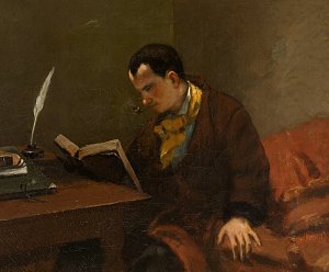 L'image représente un homme assis, plongé dans la lecture d'un livre. Il porte une robe de chambre sombre et un foulard jaune. Ses cheveux sont courts et il a une pipe dans la bouche. À côté de lui, sur une table, on peut voir de la papeterie, dont une plume, ainsi qu'un encrier. L'ambiance est intime, avec une lumière douce, ce qui suggère un moment de calme et de réflexion. La posture de l'homme indique une concentration profonde sur sa lecture.