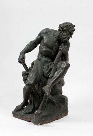 Cette image représente une sculpture d'un homme nu, assis sur un rocher. Il a une posture détendue, légèrement inclinée en avant, tenant un sceptre ou une canne dans une main et un instrument de musique dans l'autre. Sa chevelure est en boucles, et il a une barbe fournie. La sculpture semble évoquer une figure mythologique ou une divinité, avec un détail soigné sur les muscles et les drapés. Le matériau semble être du bronze, donnant à l'œuvre une apparence solide et intemporelle.