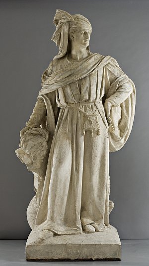 Cette image représente une statue en plâtre d'une femme drapée dans des vêtements classiques. Elle se tient debout et semble avoir une posture confiante. Ses vêtements sont ornés de plissés, et elle tient un objet dans une main, tandis que l'autre est posée sur sa hanche. Son expression est sérieuse, et elle porte un bandeau dans les cheveux. La statue dégage une impression de force et de dignité, évoquant le style artistique des sculptures antiques. Le fond est neutre, mettant en valeur la finesse des détails de la statue.