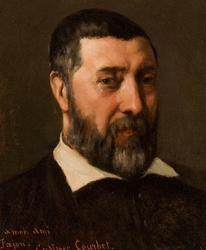 L'image représente un portrait d'un homme avec une barbe, vêtu d'une chemise à col blanc et d'une veste sombre. Son expression est sérieuse et il regarde le spectateur. Le fond est sombre, ce qui fait ressortir les traits du visage et la richesse des textures de la peinture. L'œuvre est signée, indiquant une dédicace à un ami, ce qui suggère une relation personnelle entre le peintre et le sujet.